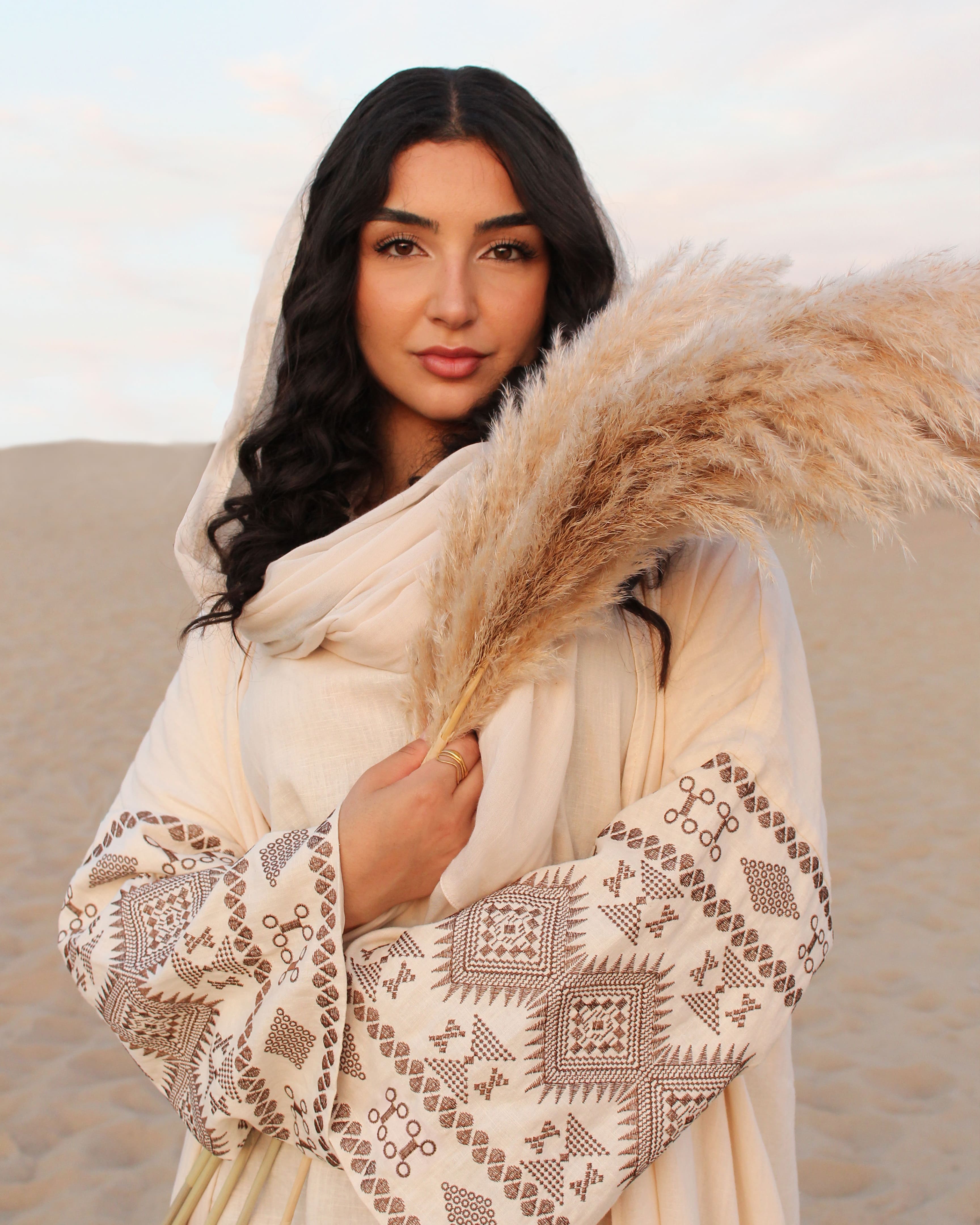 Frau in beiger Sahara Abaya von Purpose & Faith – islamische Mode in natürlicher Outdoor-Kulisse